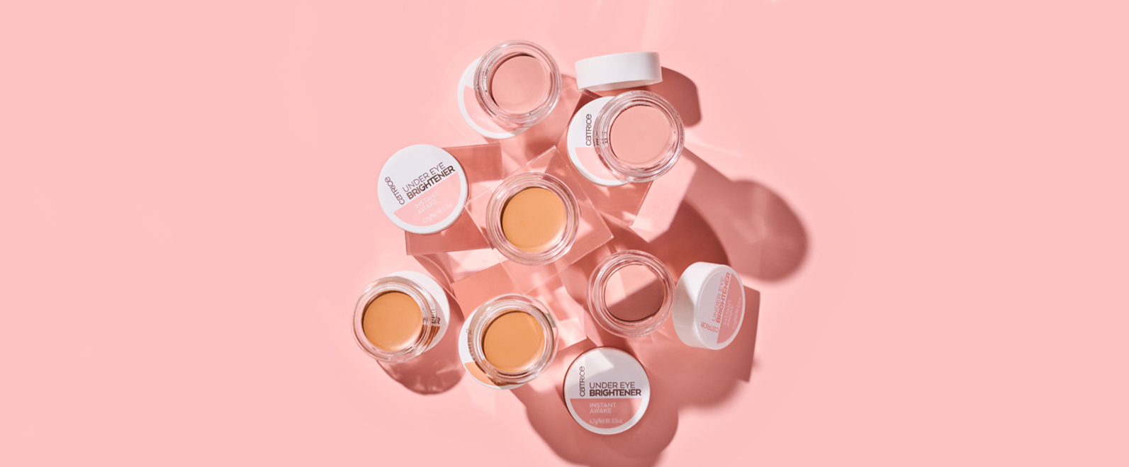 Different Shades of Under Eye Brightener behind a pink background
