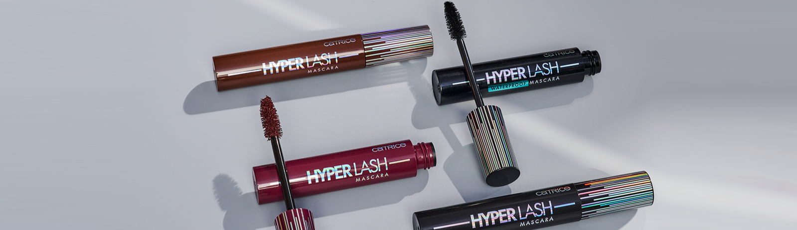 Hyper Lash Mascara in Black and Burgundy behind a Gray background 