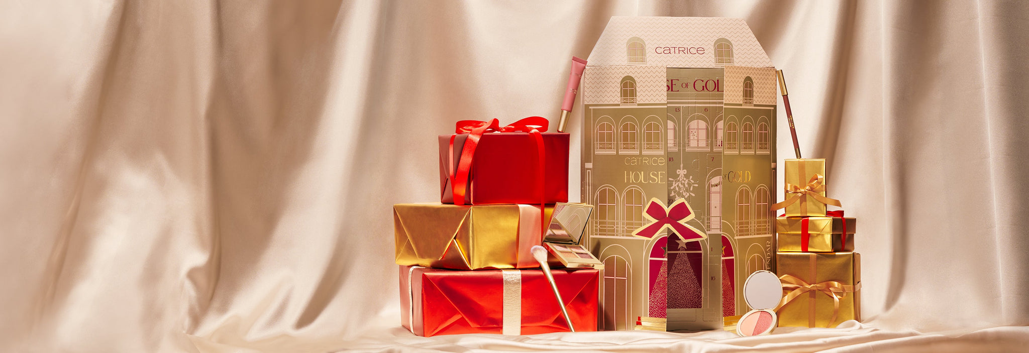 Catrice House of Gold Advent Calendar surrounded by festive red and gold gifts and beauty products.